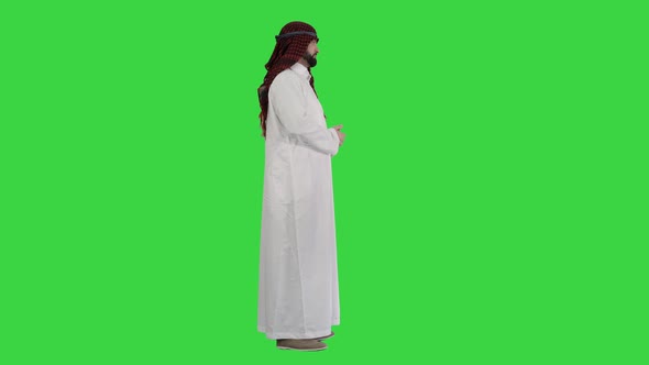 Arab Man Wearing Keffiyeh Making Wellcome Gesture on a Green Screen, Chroma Key.