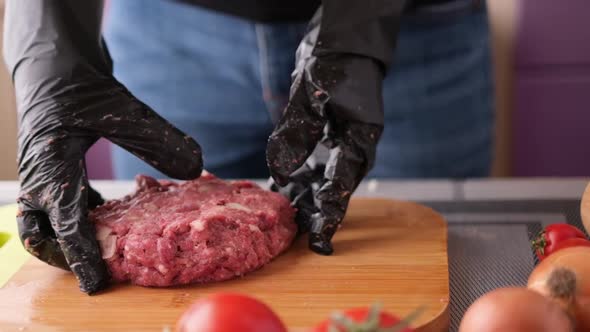 Woman Beats Minced Meat for Cooking Cutlets on Wooden Cutting Board