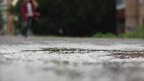 Low Angle, Close-up, Unrecognizable Kids Running Through Puddles Summer Day After Rain