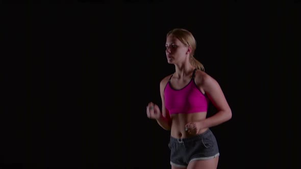 Athlete in Sports Clothes Running Lightly on a Black Screen. Slow Motion. Close Up