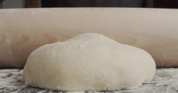 Anonymous chef rolling dough for pastry