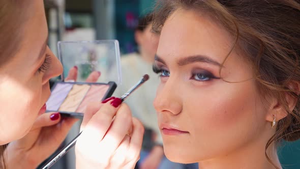 The Makeup Artist Carefully Tints the Eyelid the Girl in the Beauty Salon