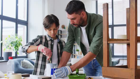 Father and Son Stirring Grey Color Paint at Home