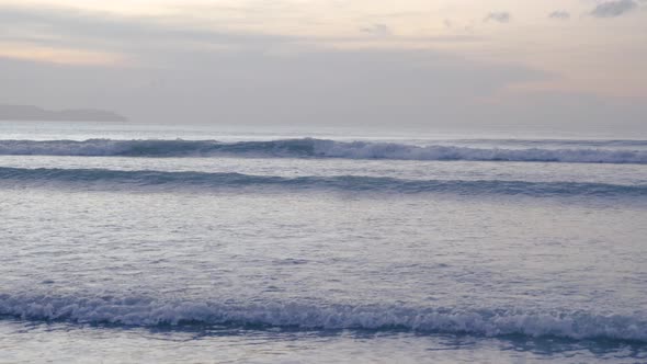 Calm waves breaking on shallow waters in Asia at dusk