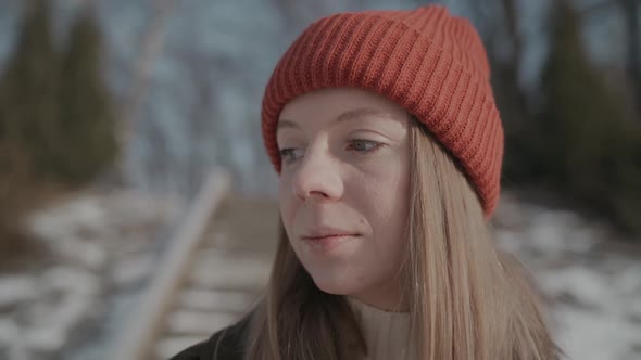 Girl in an Orange Hat in Winter Looks Around and Smiles, Happy Woman