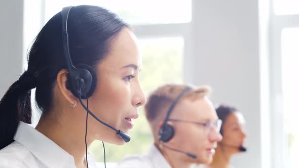 Diverse team of young professionals is working in the phone support office.