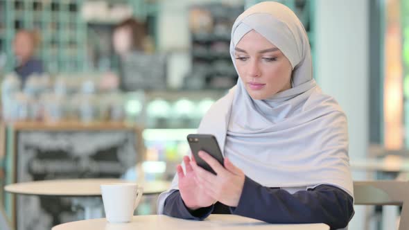 Serious Young Arab Woman Using Smartphone 