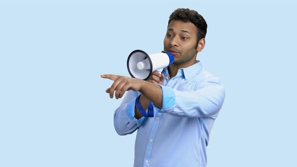 Indian Man Using Megaphone on Color Background