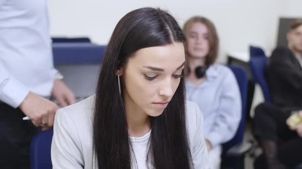 Embarrassed Young Woman Sitting in Office Working As Unrecognizable Man Putting Hand on Shoulder