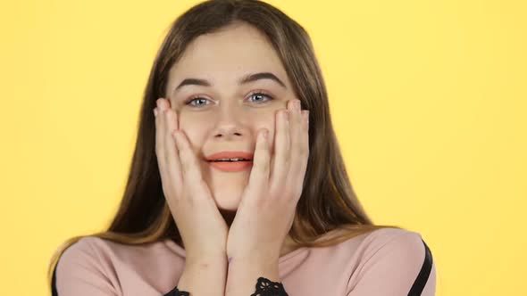 Close-up Teenage Posing Surprisingly on Yellow Background. Slow Motion