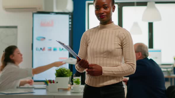 African Woman Manager Looking at Camera Smiling Holding Clipboard