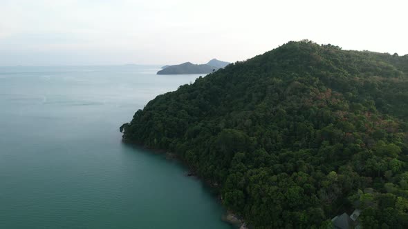 large mountain hill on a secluded tropical island in thailand during sunset, aerial