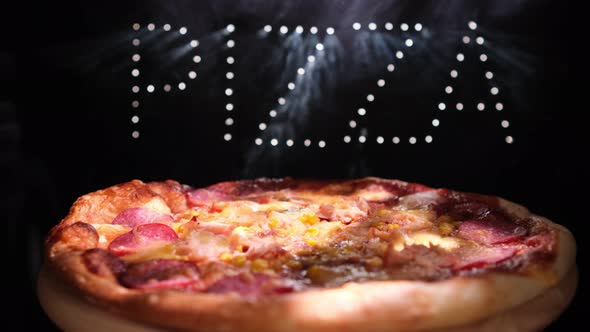 Delicious Fresh Italian Pizza On A Black Background With  The Effect Of Light Inscription Pizza