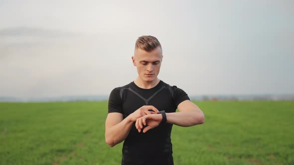 The Athlete is Standing on a Field with Green Grass