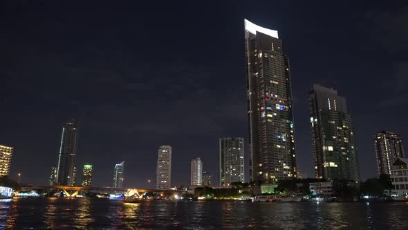 Corporate Buildings on The River Bank in The Metropolis. Night Time, Light from The Office Windows.