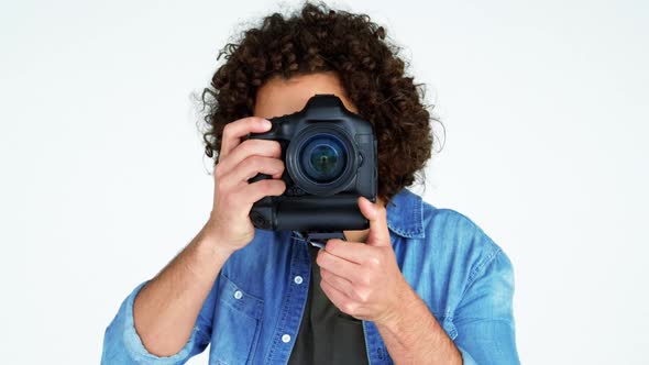 Photographer showing visiting card while taking photo with digital camera