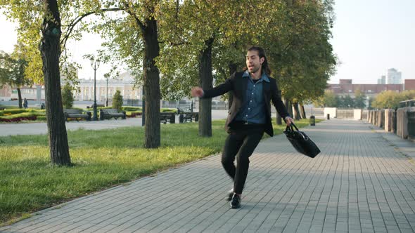 Endless Loop of Excited Young Businessman Walking and Jumping in City Street Expressing Joy