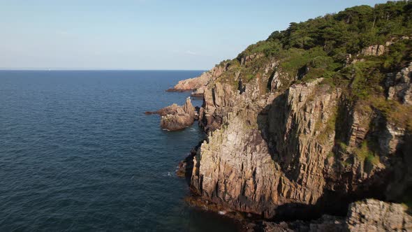 Cinematic fast flying aerial view of coast with cliffs, forest and ocean, Kullaberg Sweden