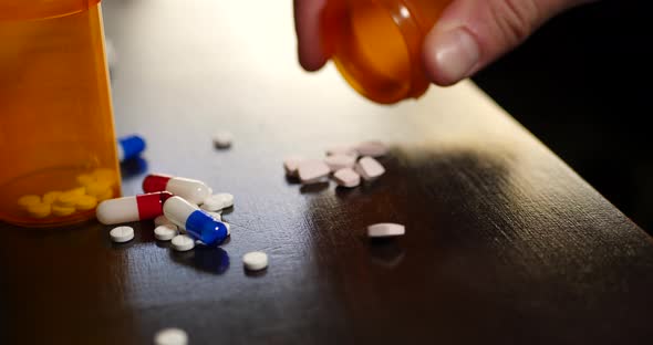 Prescription drug pills, narcotic tablets, pain killers and pharmacy bottles on a table.