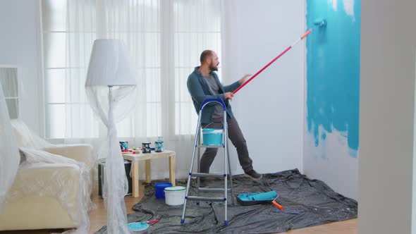 Handyman Dancing and Painting Wall