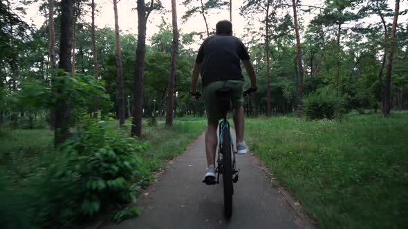 young guy rides a bike in the park. motion