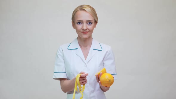 Nutritionist Doctor Healthy Lifestyle Concept - Holding Orange Fruit