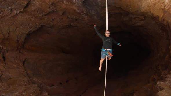 Top View on the Man Lying on the Slackline Over a Huge Quarry Extreme