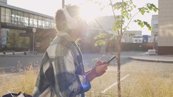 Girl Listening to Music in Earphones Outdoors