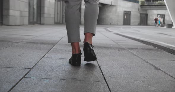 Unrecognizable Feet of Young Businessman Walking in City Street
