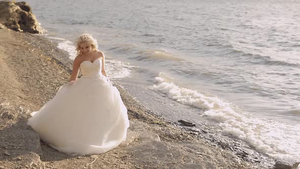 Beautiful and Lovely Bride Walking Along the Coast of the Sea