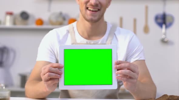 Cheerful Bachelor Holding Tablet With Green Screen, Food Delivery Service App