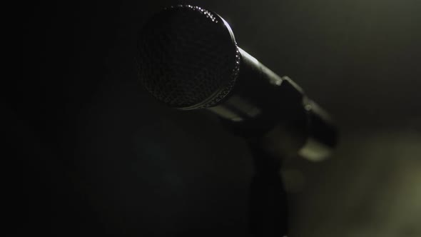The Silhouette of the Microphone in the Dark on Stage