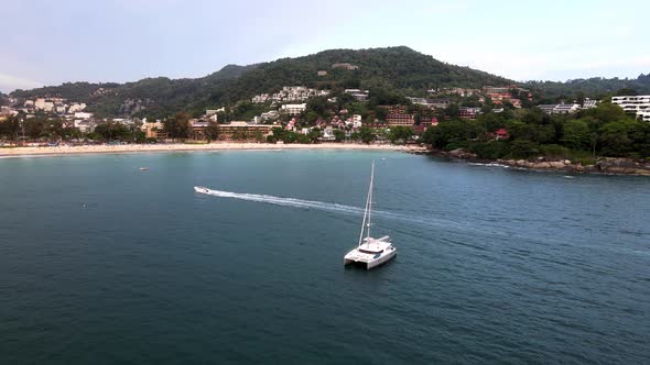 Aerial Flying Over White Yacht With Parasailer Going Past At Over Kata Beach In Phuket. Dolly Forwar