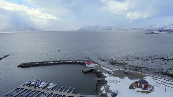 Ariel orbiting shot of the Ase Harbor Norway with stunning views of snow covered mountains and the d