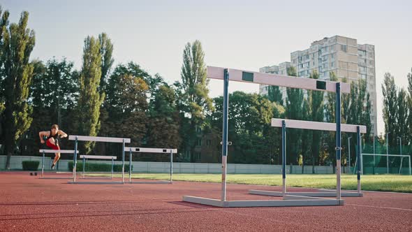 Low Angle Shot of a Professional Sportsman Running a Distance with Obstacles