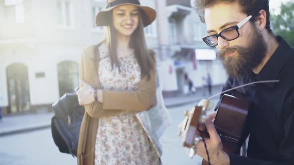 Handsome Guy Is Playing Acustic Guitar While Girl Listening