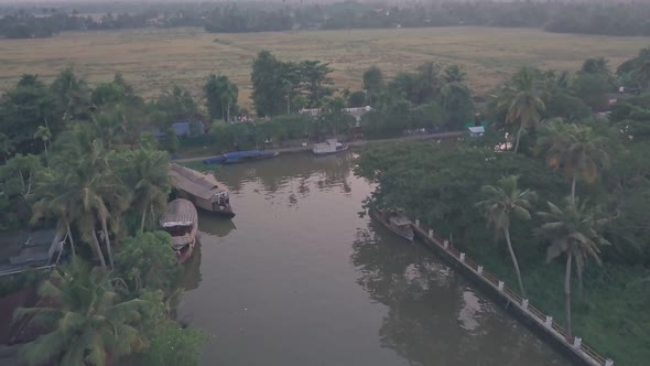 Houseboats in Kerala backwaters and local life at sunset at Alleppey, India. Aerial drone view