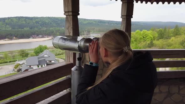 Attractive Female Traveller Using Binoculars for Looking Around Valley Near the Old Castle