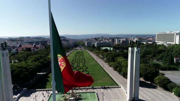 Close Up Aerial View of Portugal Flag Waving in the Wind on Eduardo VII Park Lisbon