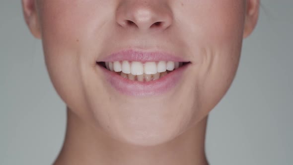 Close-up portrait of young, beautiful and natural woman opening her mouth and smiling.