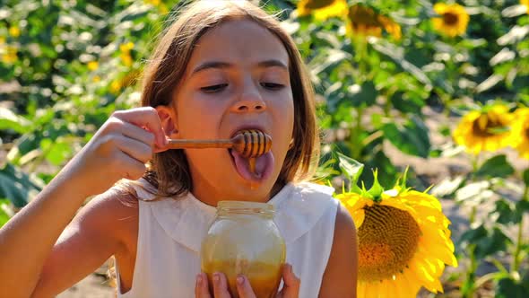 A Child Eats Honey From Flowers