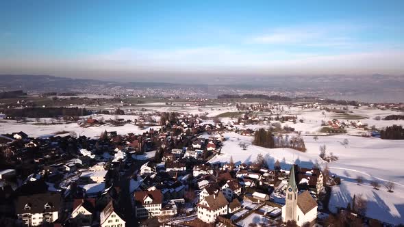 Beautiful aerial view over a small village on a hill next to the lake of zurich