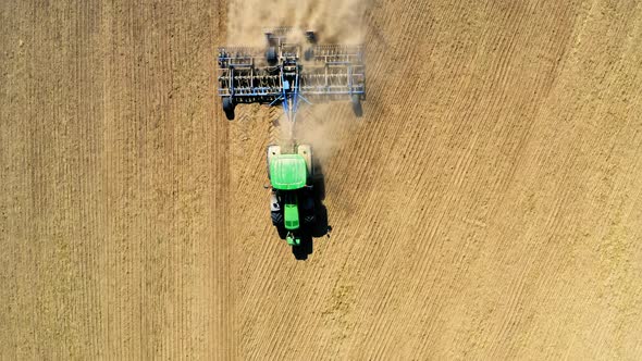 Top view of tractor plowing field on autumn