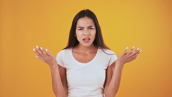 Disappointed and Upset Female Has Grabbed Her Head Asking What Posing on Orange Background