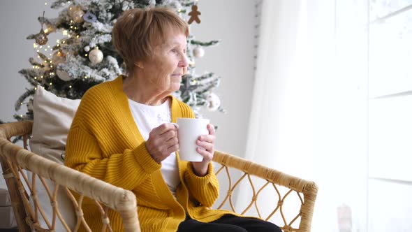 Senior Grandmother Relaxing At Home With Cup Of Coffee At Christmas Time