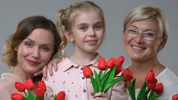 Women of Three Generations Holding Tulips, Family Tradition to Celebrate 8 March