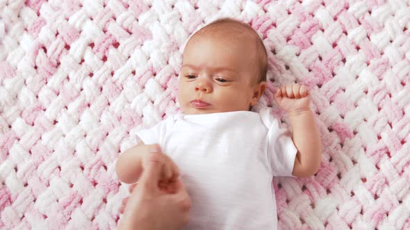 Sweet Baby Girl Lying on Knitted Plush Blanket