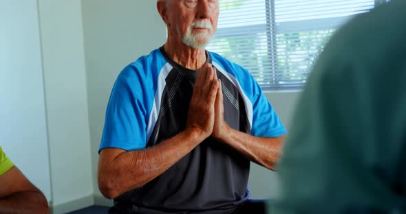 Front view of active Caucasian senior man performing yoga in fitness studio 4k