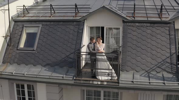 Caucasian Newlyweds Bride Embracing Groom on Balcony in Hotel Room Aerial View