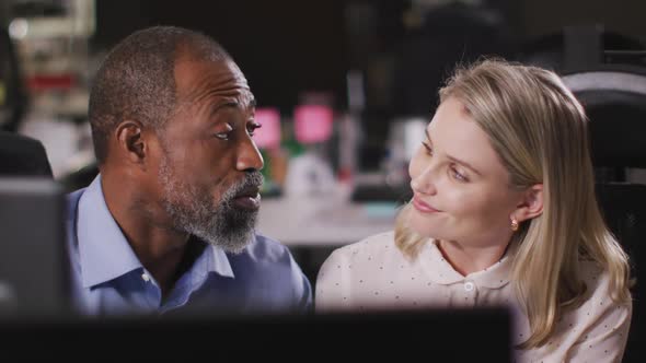 Professional businessman and businesswoman discussing while sitting in modern office in slow motion